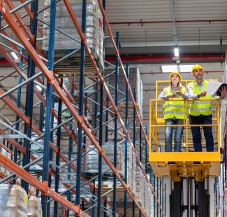Warehouse workers on lift work platform checking inventory